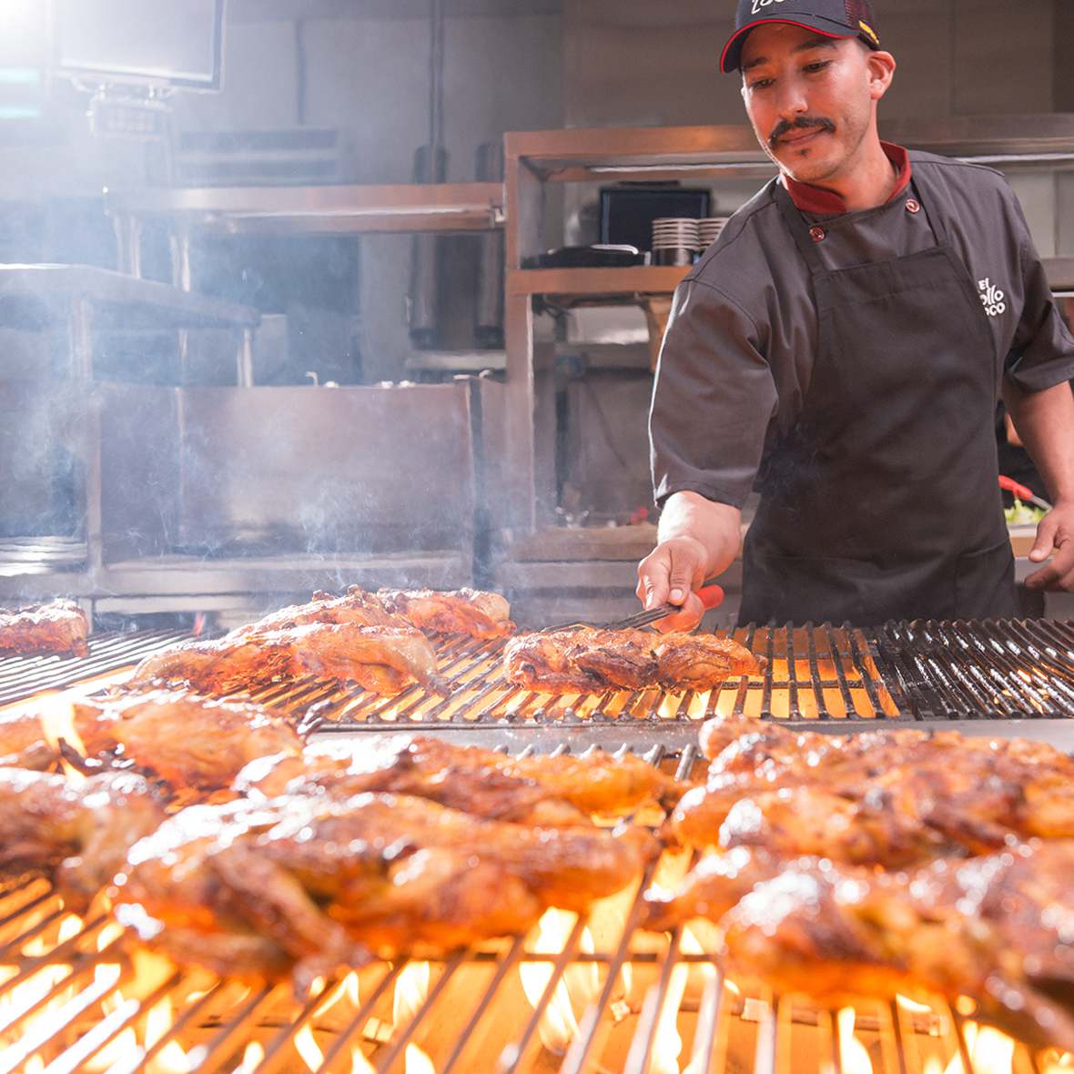 Grill master cooks citrus-marinated chicken over open flame