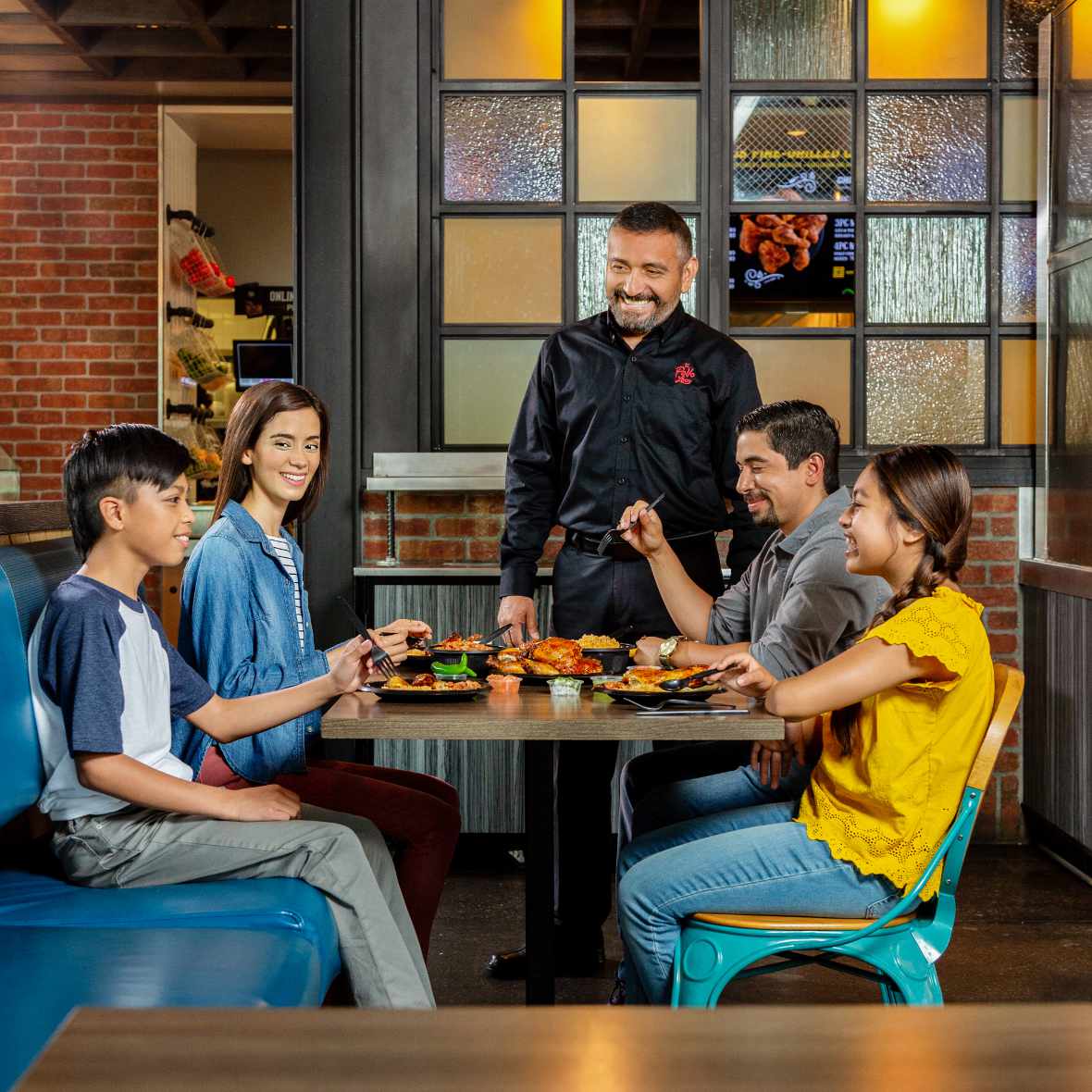 Family enjoying a meal inside El Pollo Loco.