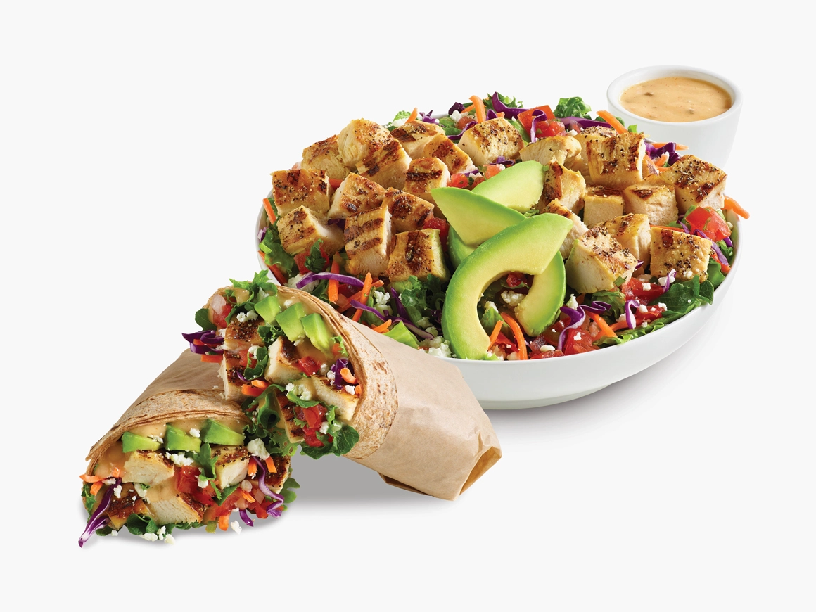 Citrus Avocado Fresca Salad in a white bowl with a side of citrus vinaigrette dressing.