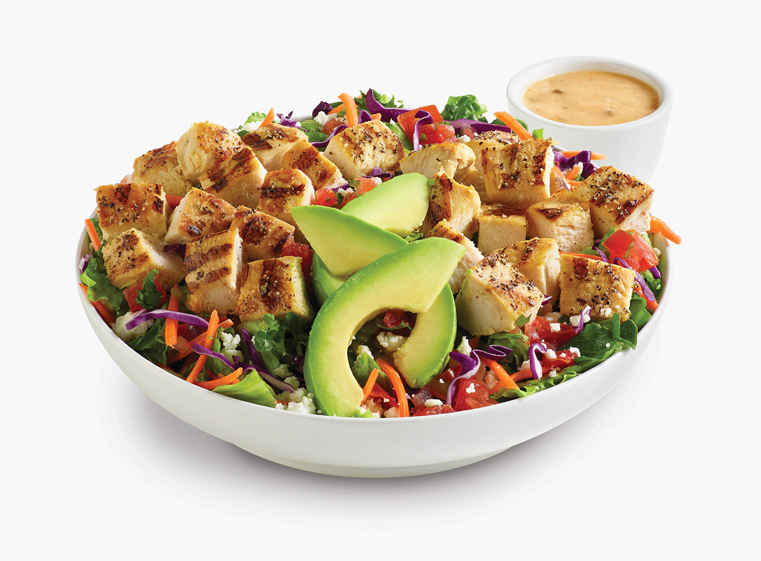 Citrus Avocado Fresca Salad in a white bowl with a side of citrus vinaigrette dressing.