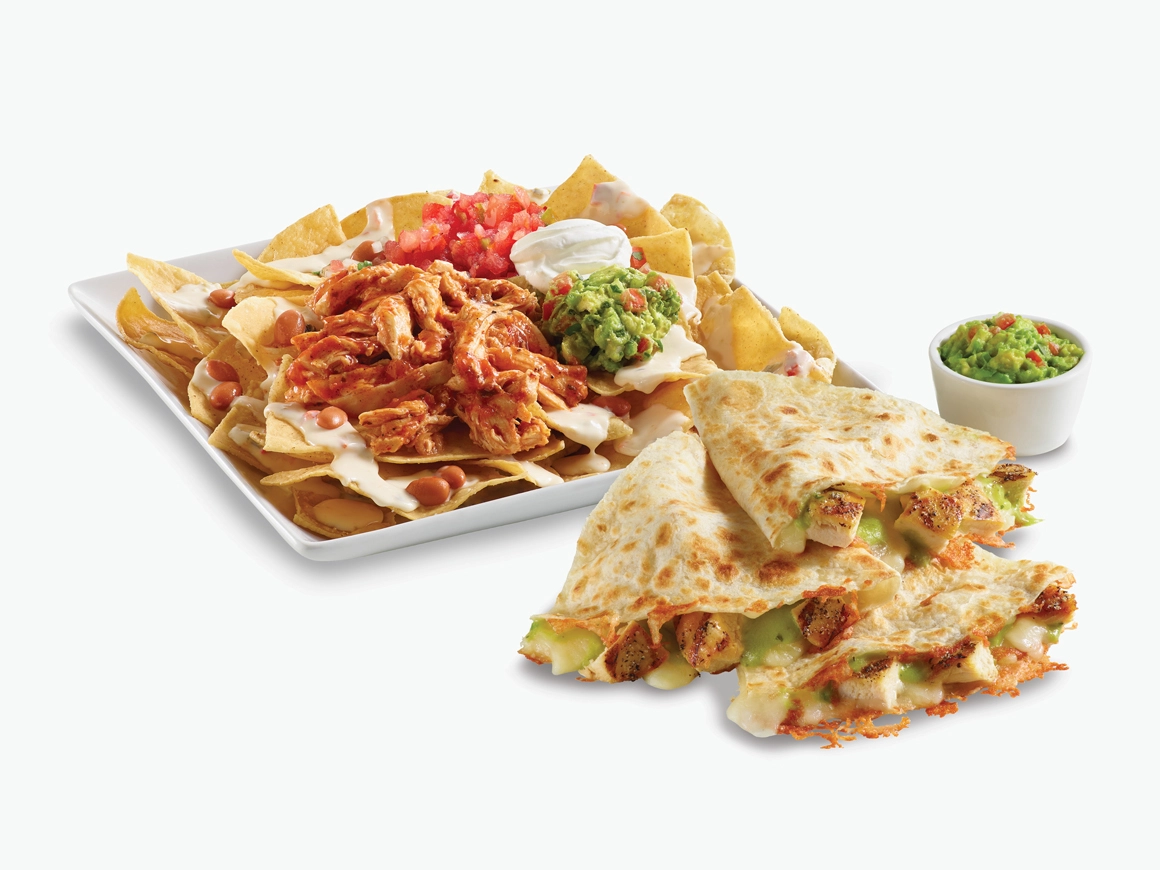 Chicken Nachos on a white plate and Salsa Verde Quesadilla with a side of guacamole in a white ramiken