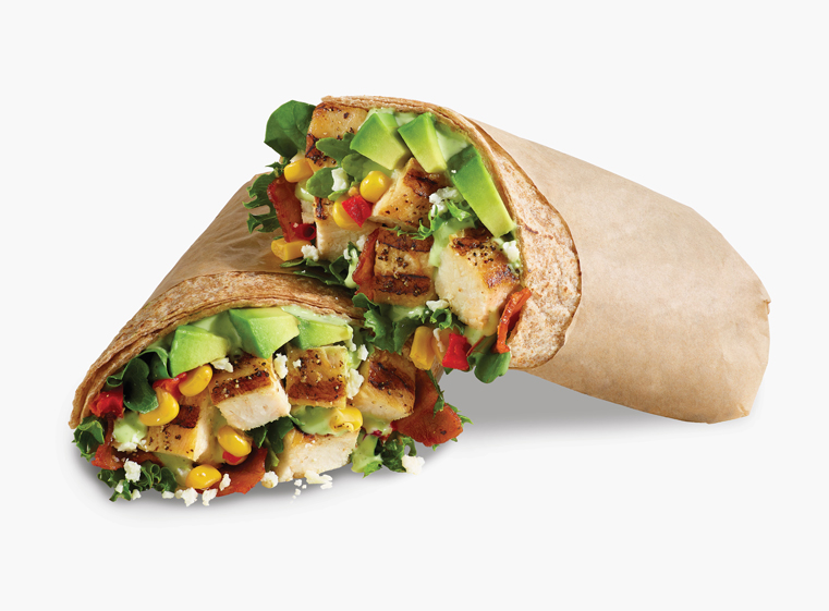 Mexican Cobb Fresca Wrap cut in two leaning against each other with a tan paper wrap.