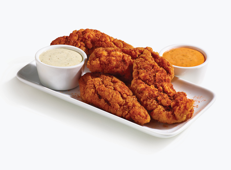 4 piece spicy tenders on a white plate with loco sauce and baja lime sauce in white ramekins